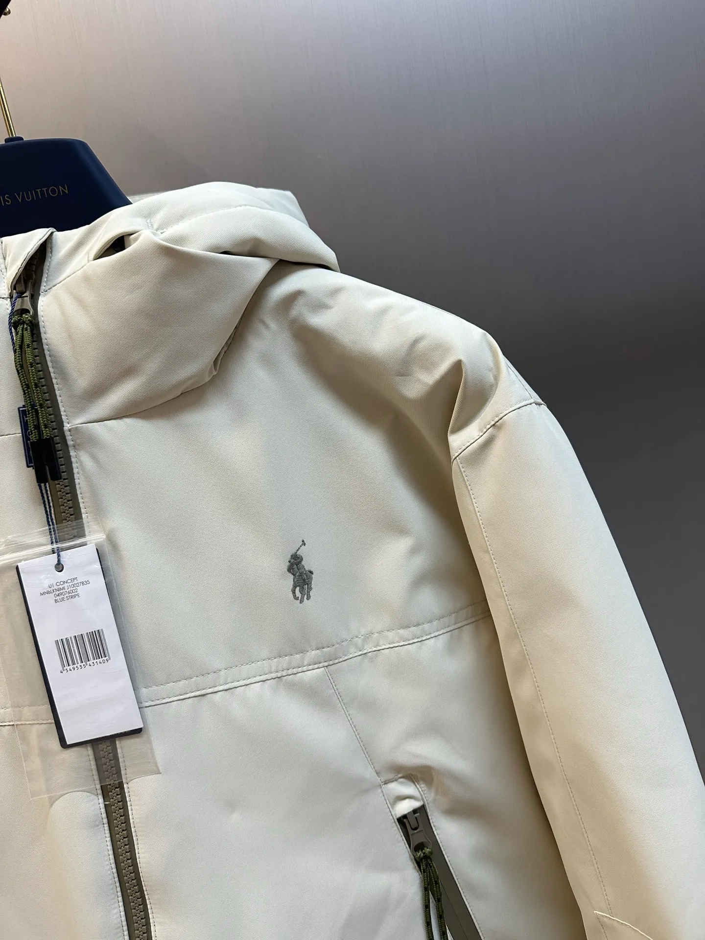 P970 Ralph Lauren logo hooded down jacket. The density of high-density nylon taffeta is about 210T-300T. The surface is smooth and slightly matte. It has excellent windproof and waterproof performance (with DWR water-repellent treatment). It has strong wrinkle resistance and is easy to care for. It is in line with the positioning of American casual "durable and practical".  The inner lining is made of 100% polyamide. The high-density and tight weaving process prevents fine lint from getting out of the gaps in the fabric. The smooth surface improves the putting on and taking off experience, and the excellent wear and tear resistance ensures damage caused by frequent use, while the light and soft texture does not affect the overall weight.  It uses 90 white duck down with a weight of 220g to ensure excellent thermal insulation performance. After strict screening and processing, the velvet is not easily drilled, ensuring durability. The classic jacket has a slightly loose fit, with slightly dropped shoulder lines (the shoulder width is 1-2cm wider than the standard fit). The length reaches the hips, and the sleeves are slightly tapered straight sleeves, taking into account freedom of movement and casual style.  The adjustable Velcro on the cuffs allows you to freely adjust the tightness according to the thickness of your wrist and personal preferences, effectively preventing cold wind from intruding, and improving the warmth performance. Two zippered pockets on the front are convenient for placing frequently used items, and the zipper design ensures that items are not easily lost. A built-in pocket on the left side of the chest provides a safe storage space for some small private items.  The drawstring design at the hem allows you to adjust the shape of the jacket according to your body shape and dressing needs. Whether it is loose and casual or slim and neat, you can easily control it.  Polo horse logo on the left chest: flat satin stitch embroidery (satin embroidery), using 100% polyester high color fastness embroidery thread (the color number is consistent with the brand's standard red color card), the stitch density is 12-15 stitches/cm, the outline of the horse logo is clear, and the details of the rider and horse are burr-free. Precise positioning through the template (12cm from the bottom of the collar and 8cm from the placket) ensures symmetry and centering.  size：s m l xl